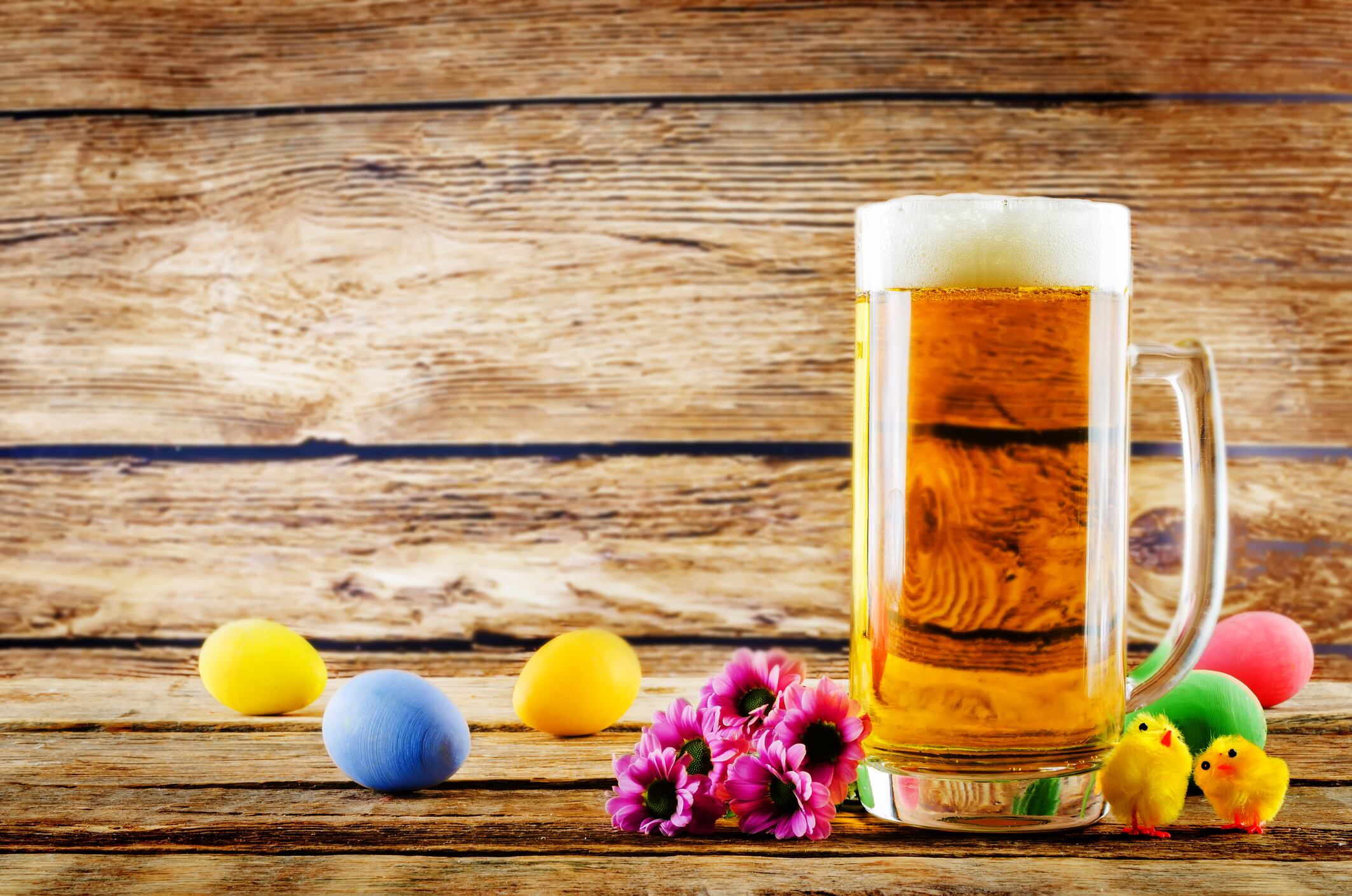 Glass of cold light beer with Easter decorations on a wood background for the Easter holidays. toning. selective focus