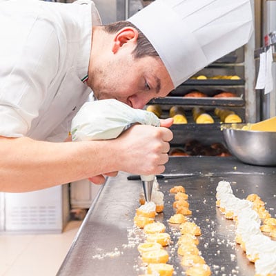 pastry-chef-filling-small-pastries-with-pastry-bag.jpg