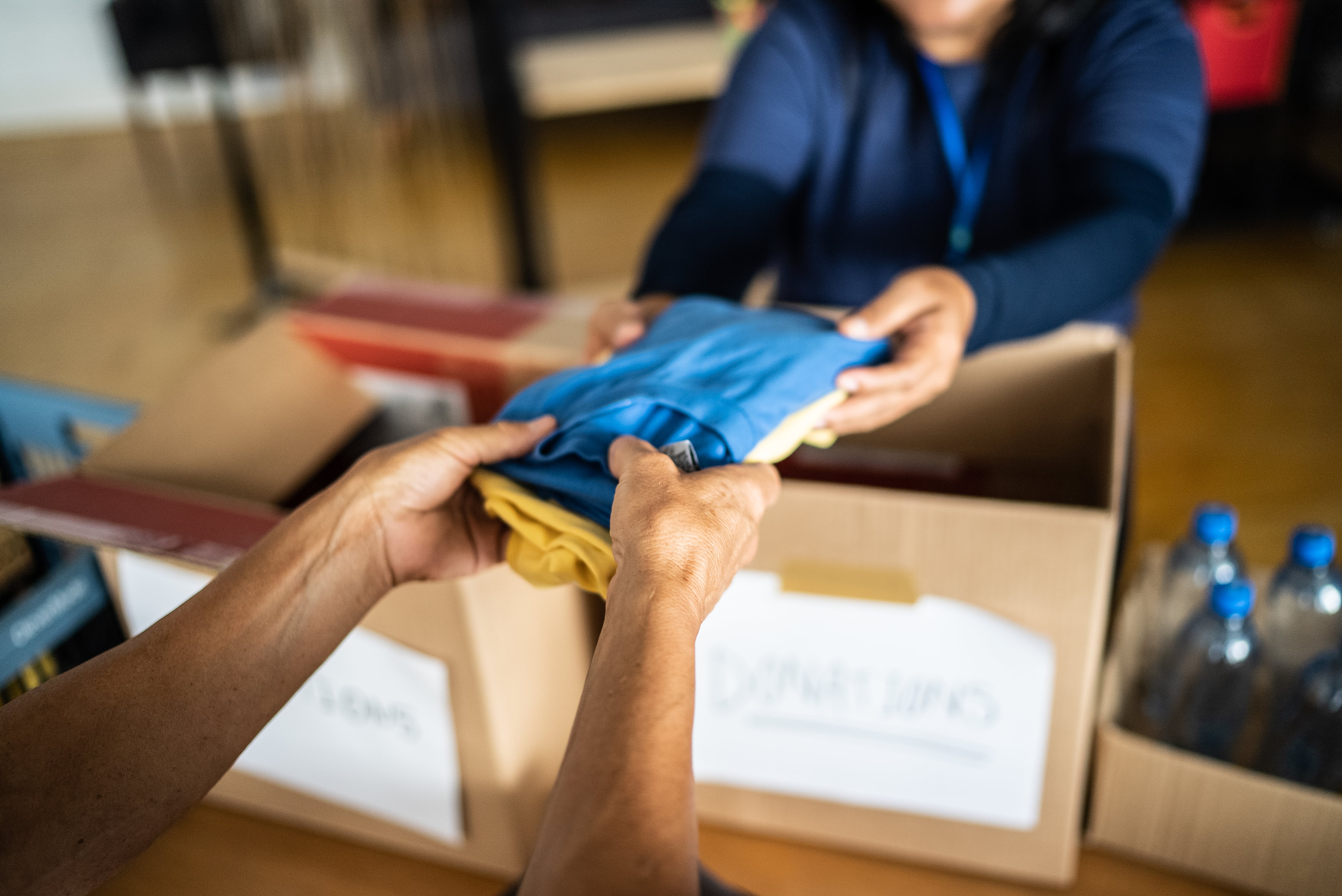Volunteer's hand giving donations to a person at a community center