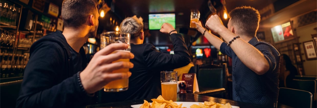Drinking beer in pub while watching sport