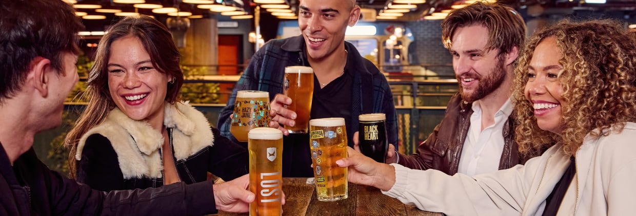 Friends drinking pints of BrewDog beer in pub at a table
