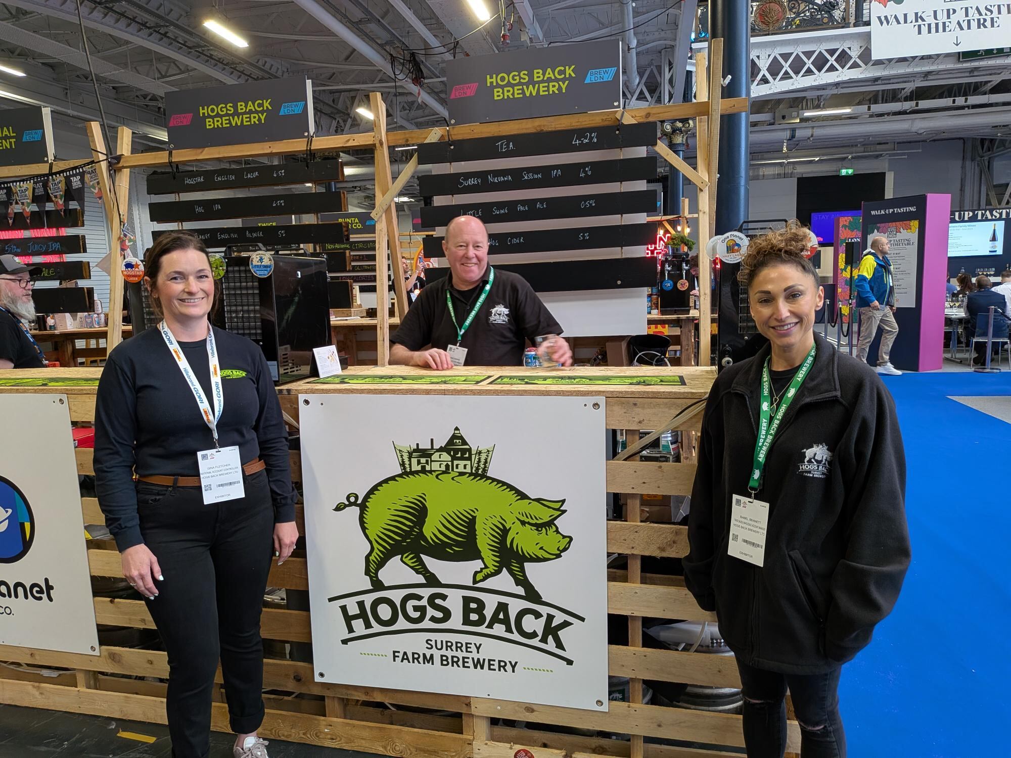 Gina Fletcher, Dominic Ronane and Isabel Bennett of Hogs Back brewery at BrewLDN area at London Wine Fair/BrewLDN/Signature Serve event at Olympia, London, 18-20 May 2026