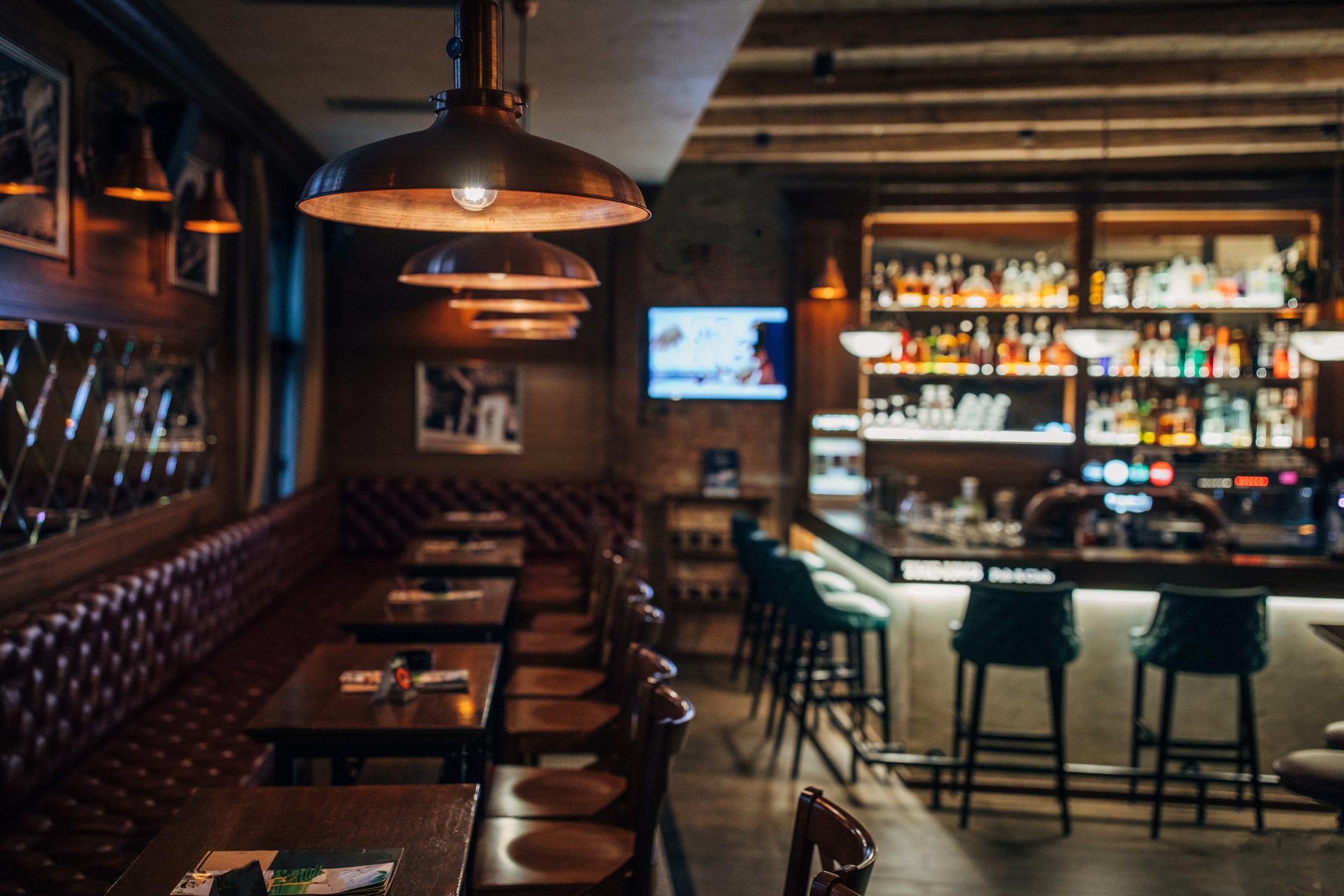 Interior of a traditional pub with tables, chairs and a bar area, as the BII calls for lower VAT to support struggling hospitality businesses.