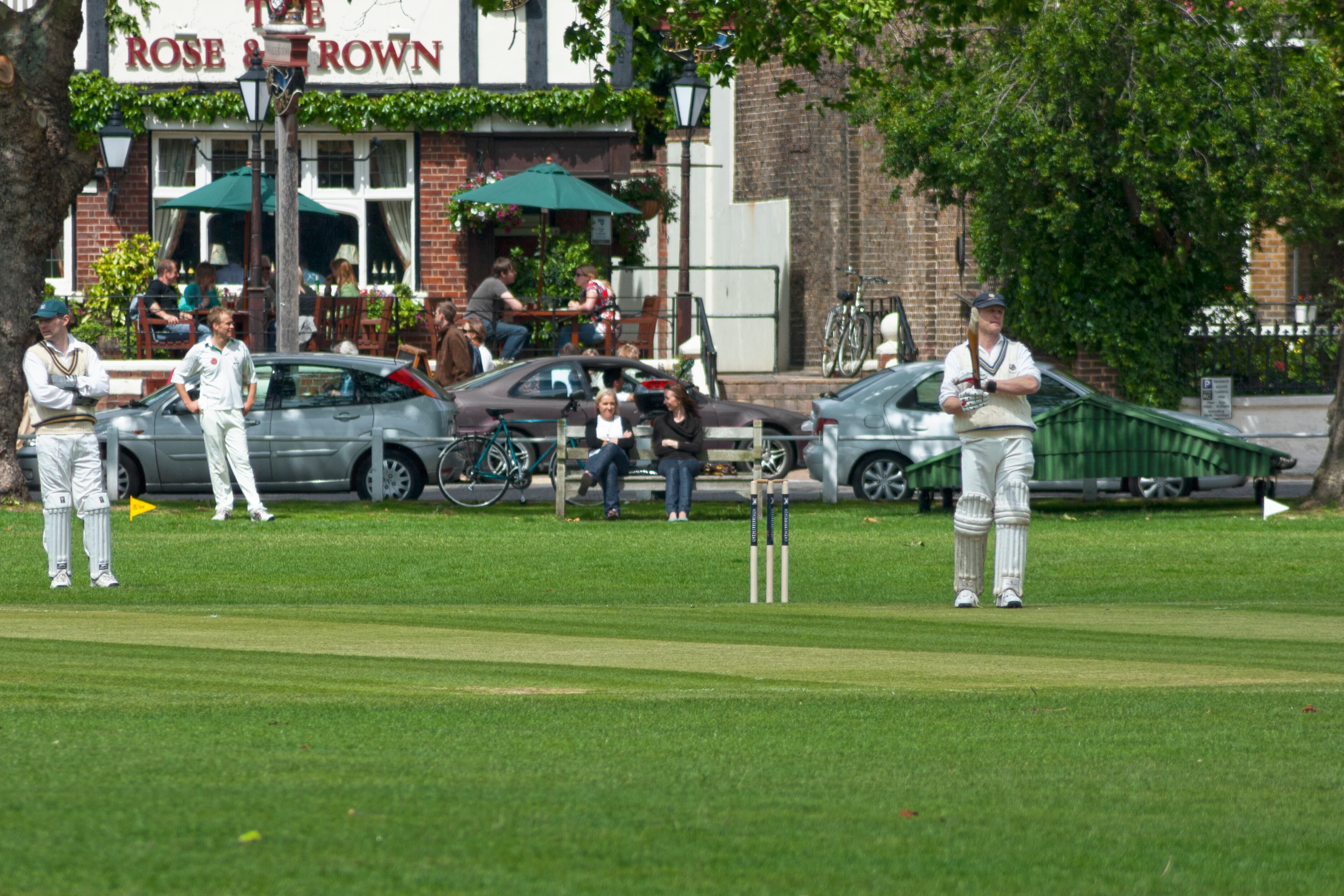 Kew, England - May 19 2007: Friendly match of cricket on Saturday morning on the field opposite of the pub “The Rose & Crown” in Kew, near London.
