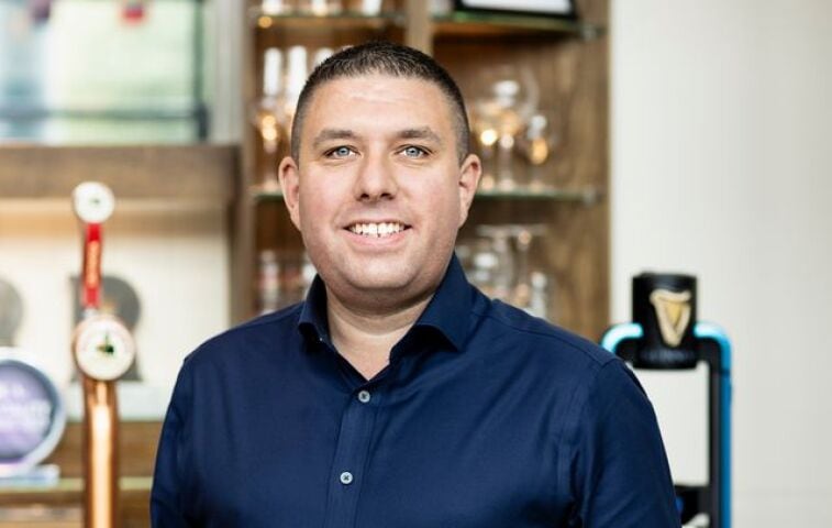 Dan Castle smiling in a professional setting, the author of an article about the future of British pubs and how new publicans are driving innovation and community engagement.