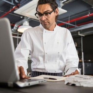 A head chef on a laptop managing restaurant costs