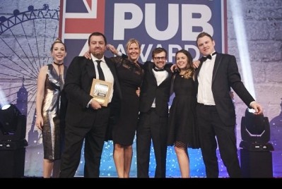 The team from the Bull, Ditchling celebrate their success with awards host Katherine Ryan