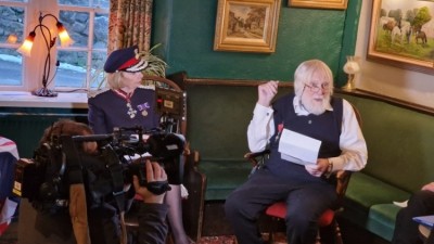 Pub setting: John Mills receives his MBE from Lord Lieutenant of Derbyshire, Elizabeth Fothergill, while the BBC films the ceremony
