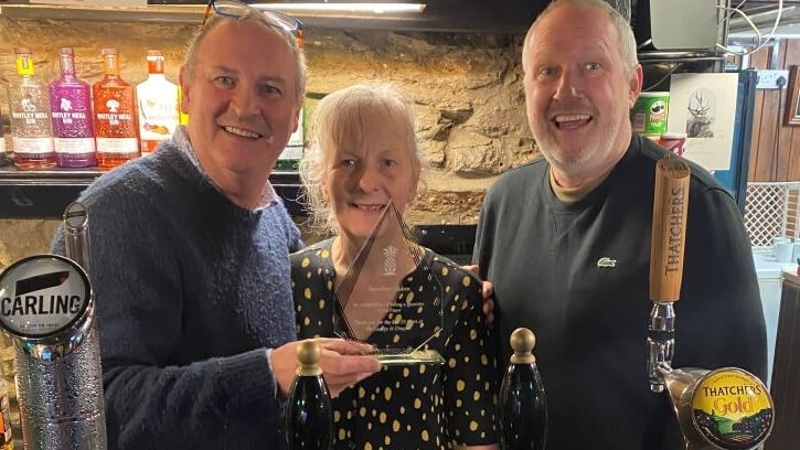 Service recognised: (l-r) Jonathan Quinn and wife Linda receive an honourable trophy from Punch Pubs & Co operations manager David Symes