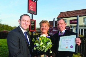Punch’s Andy King presenting Marian and Mike Rouse with a certificate and flowers.
