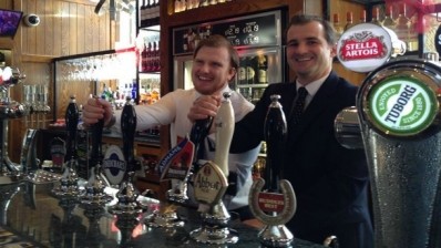 Tapped up: new pubs minister (right) pours a pint with barman (left) 