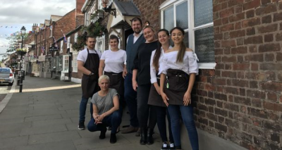 Community stalwart: licensee Stuart Wraith (centre) and his team outside the Rising Sun